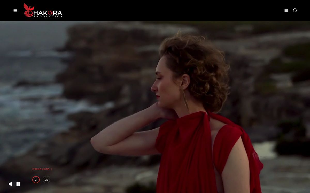 The Chakora Productions website: a cinematic portrait in a red dress against the sea.